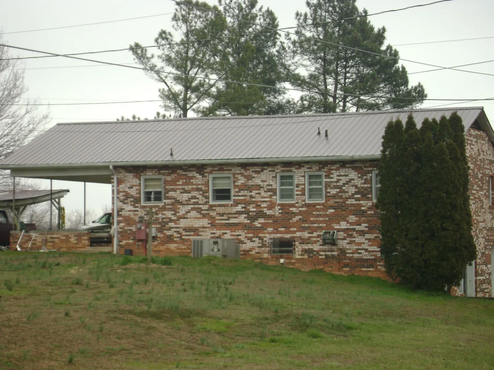 Gray metal roof on a brick split level home with a carport in Bridgewater